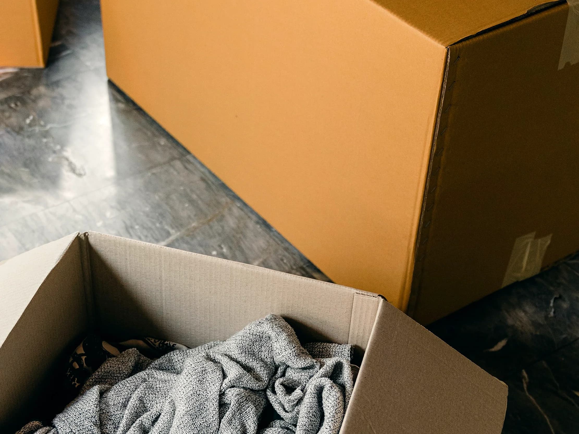 Corrugated shipping boxes sealed with packing tape on a floor