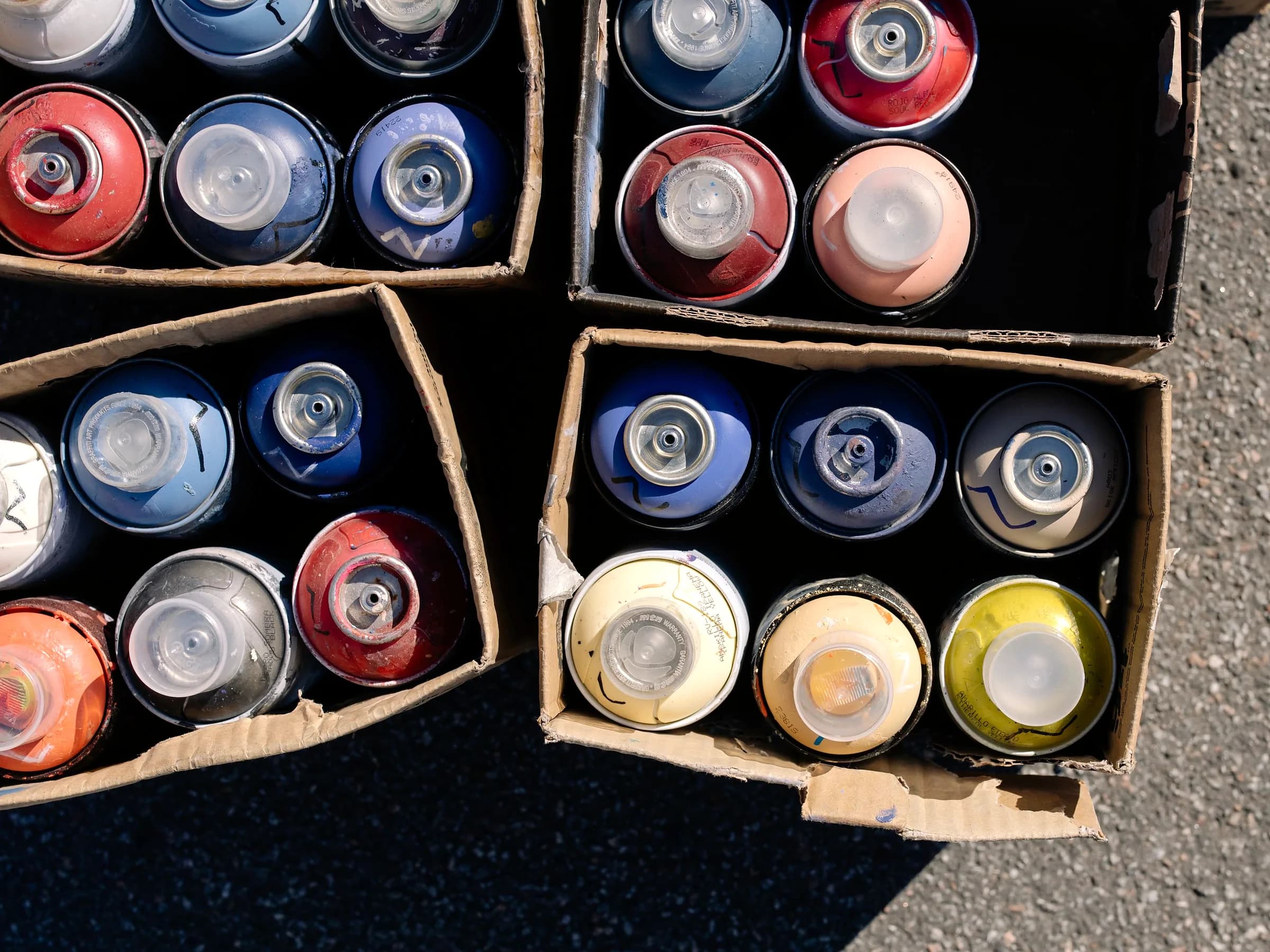 Spray paint cans packed in open corrugated cardboard boxes