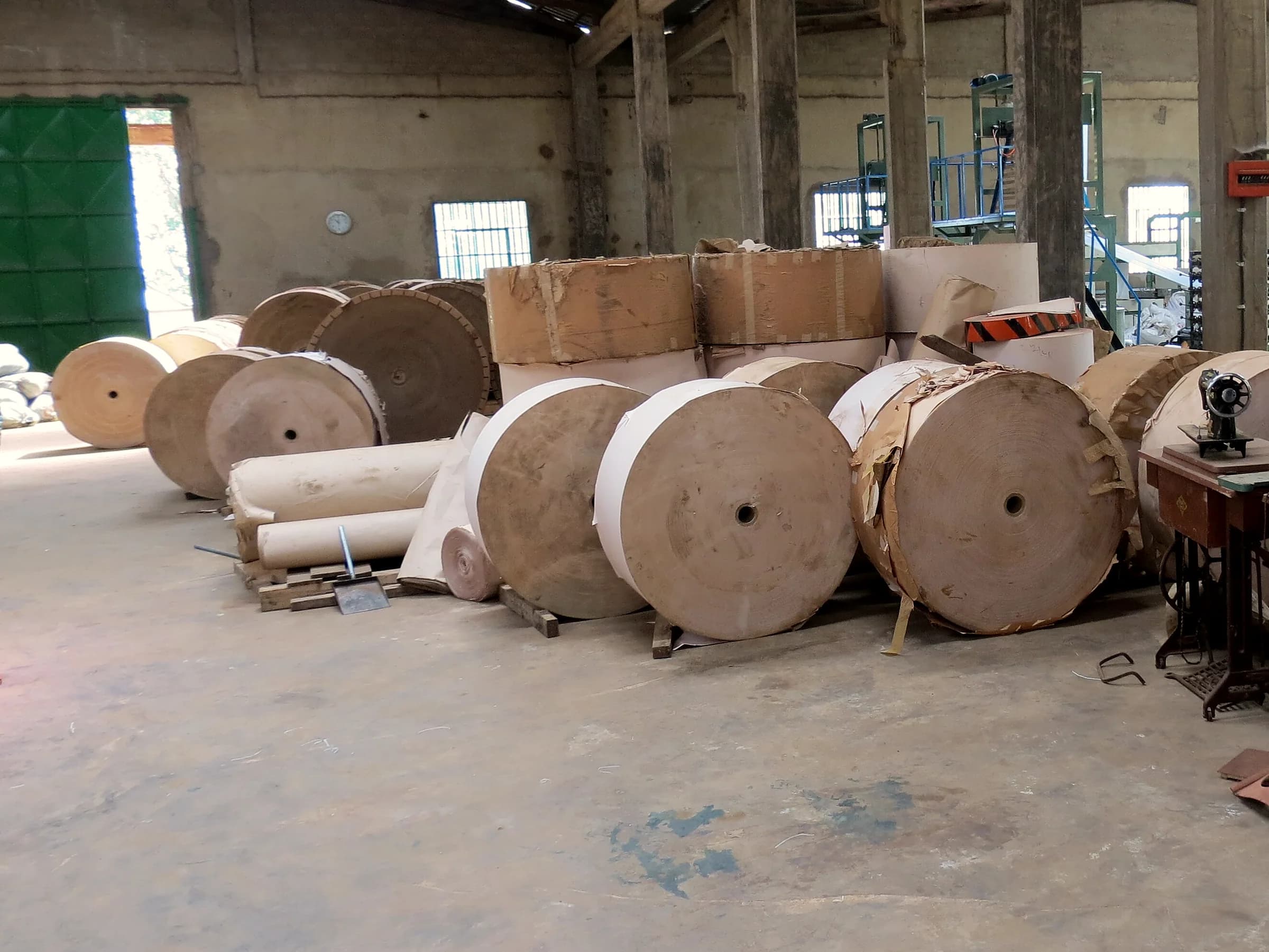 Jumbo kraft paper reels staged on a packaging factory floor