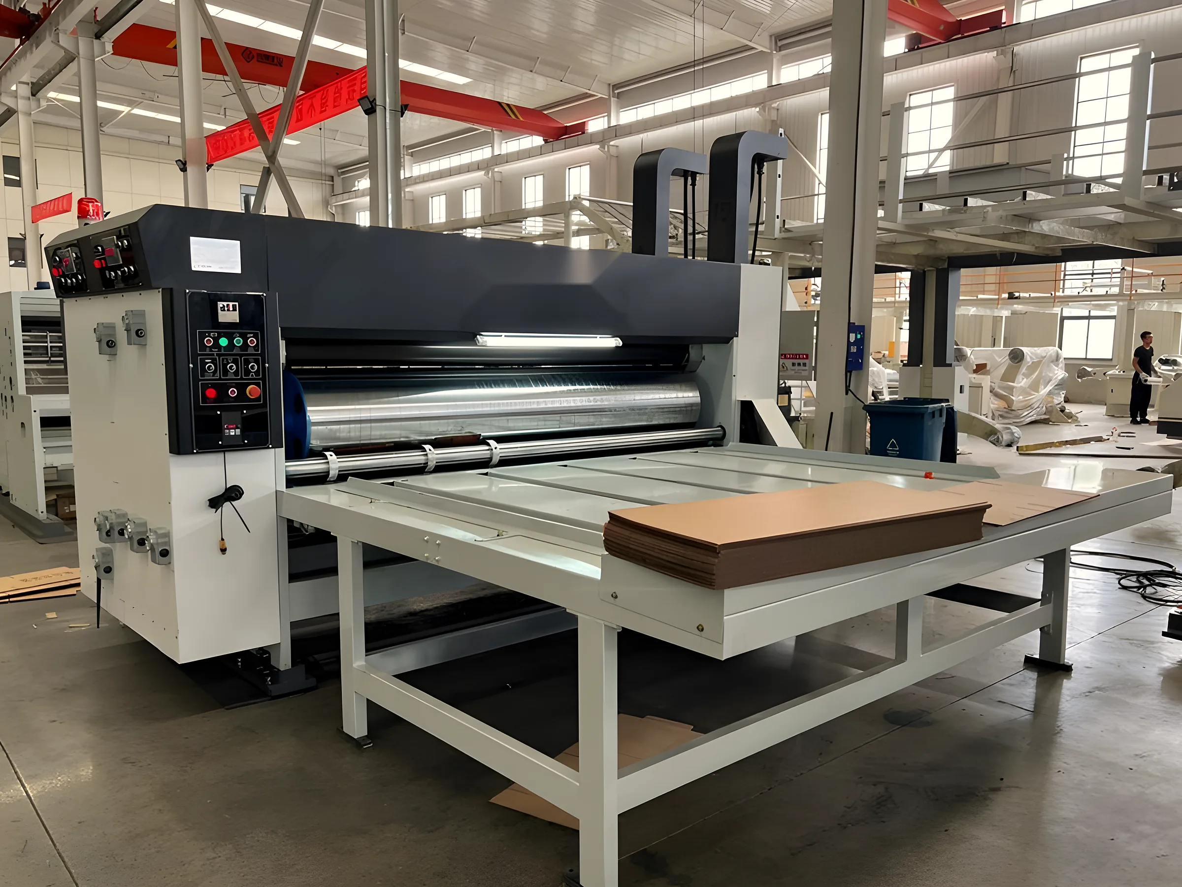 Printer slotter converting corrugated board on a factory floor