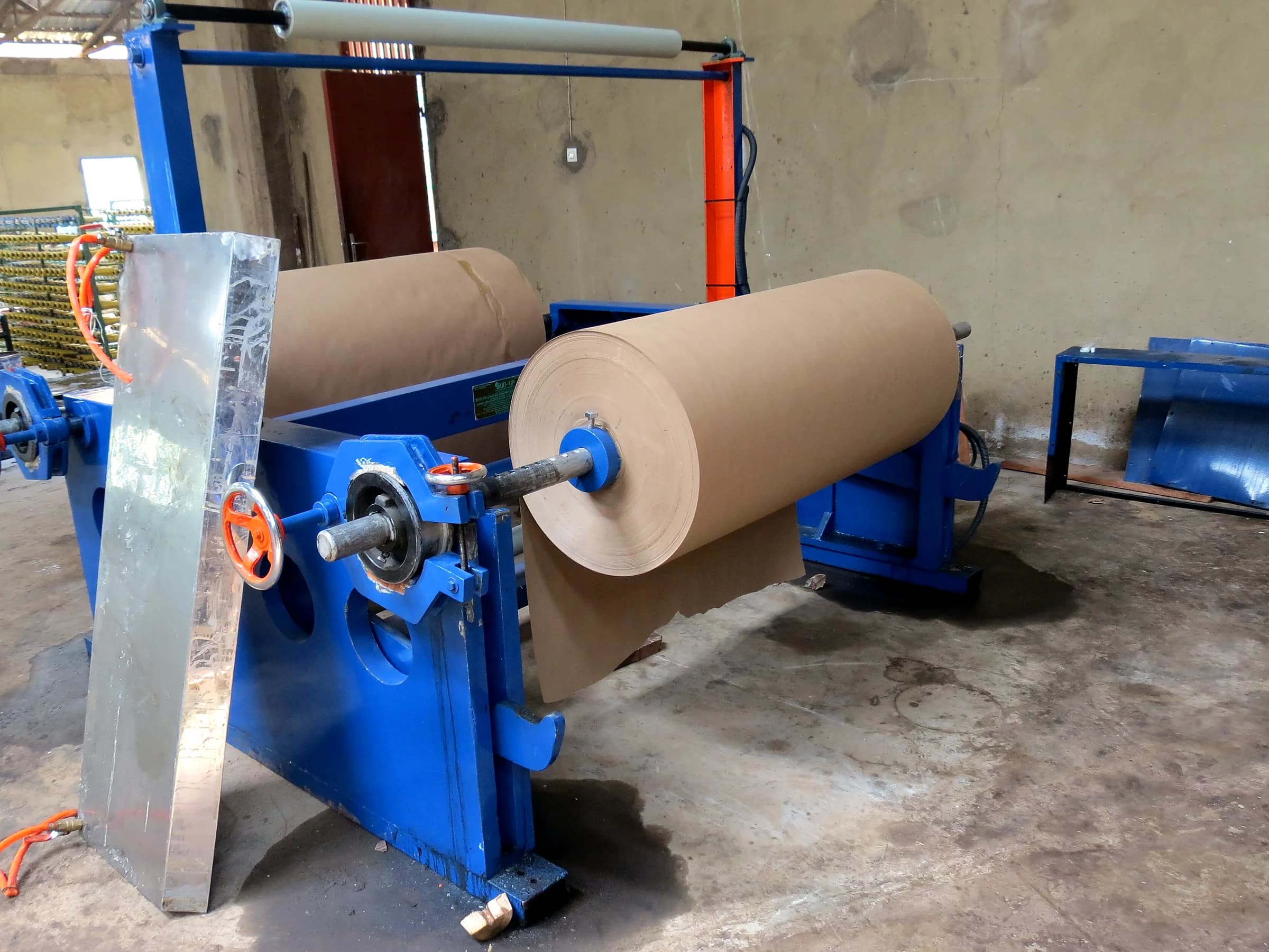 Brown kraft paper reels mounted on a packaging production machine
